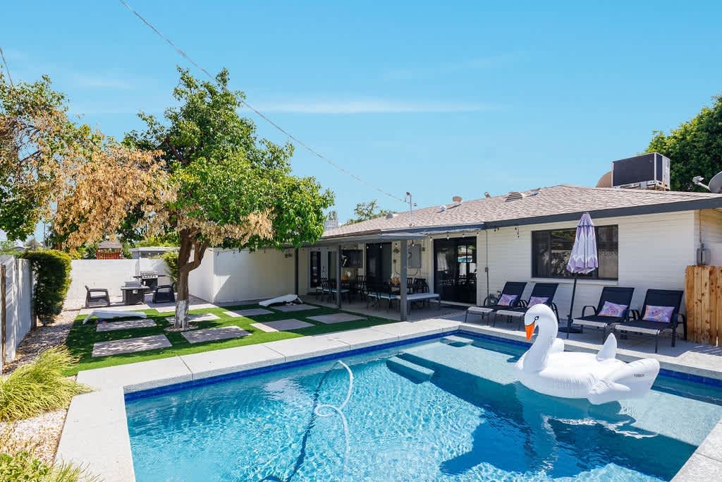 Backyard with pool, outside dining table, lounge chairs, BBQ grill, and bonfire pit.