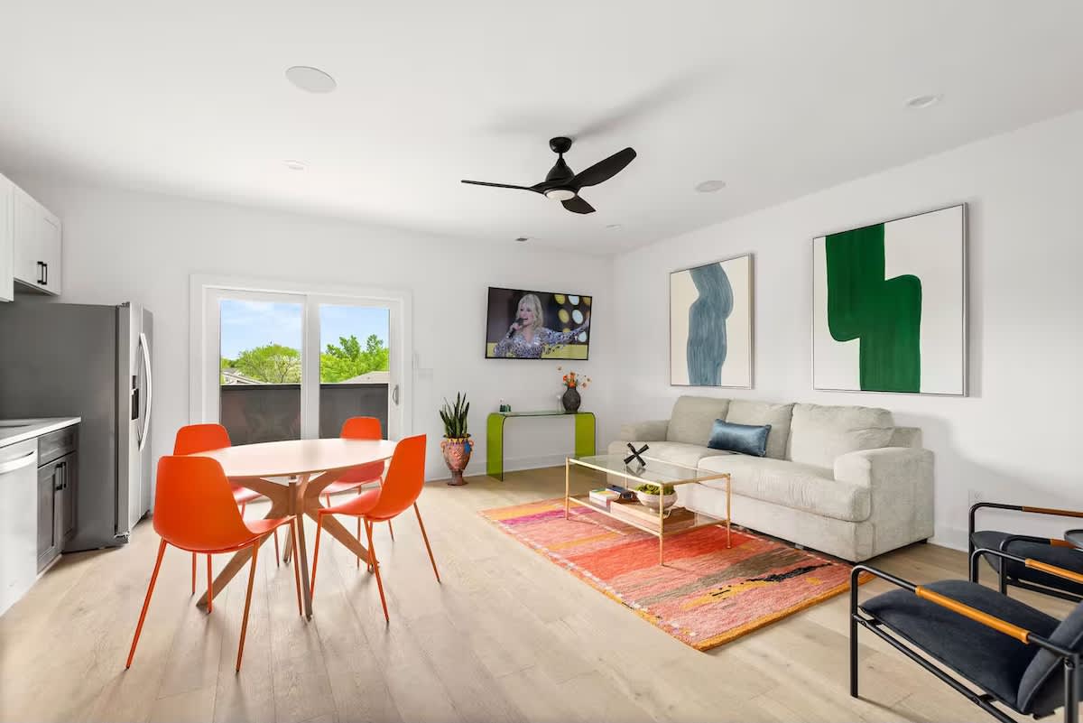 Second living area with vibrant accents, comfortable seating, a Smart TV, and a fully equipped kitchen in view, creating an easy flow for relaxing, dining, and gathering. (3rd Floor)
