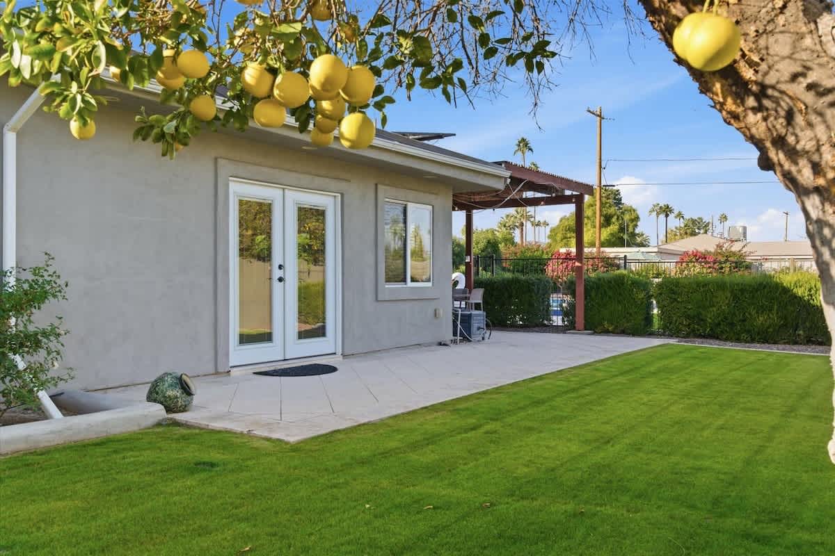Private backyard with a sparkling pool, sun loungers, outdoor games, and a covered patio with an outdoor dining area and a BBQ grill.