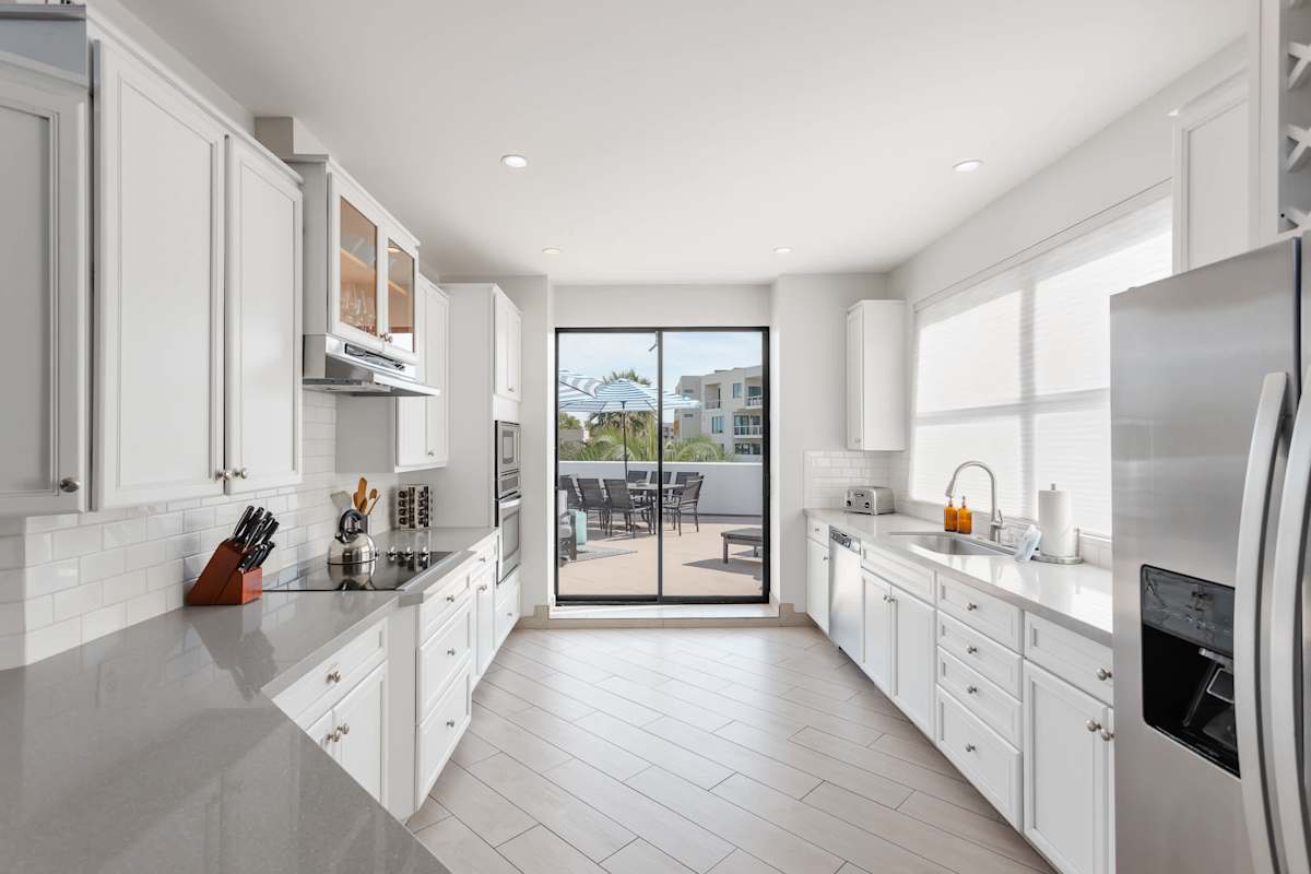 Sleek, well-equipped kitchen with stainless steel appliances, ample prep space, bar seating, and everything you need for meals, snacks, and easy entertaining.