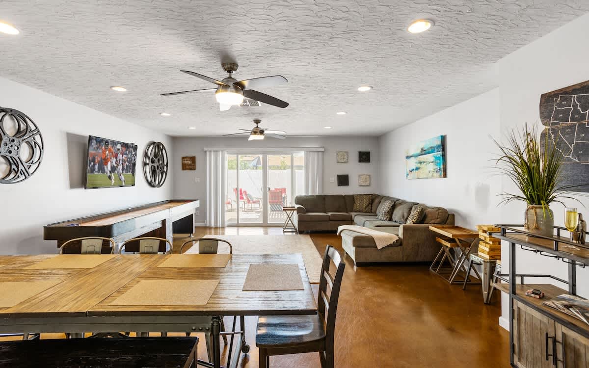 Large open floor Primary Living Area featuring a Smart TV, Dining Area, Shuffle Board, Bar Cart and designer furnishings.