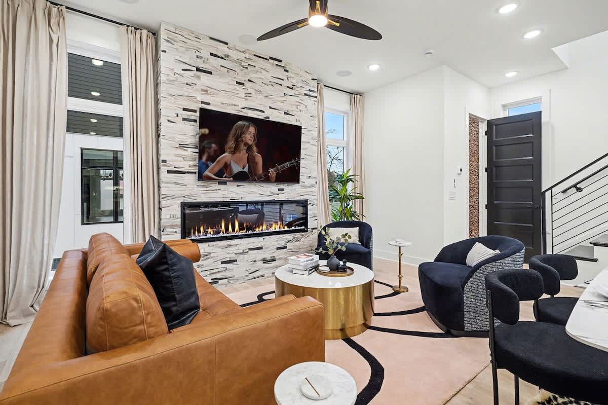 2nd Floor: Bright and open living area with plush furnishings, smart TV, and a fireplace.