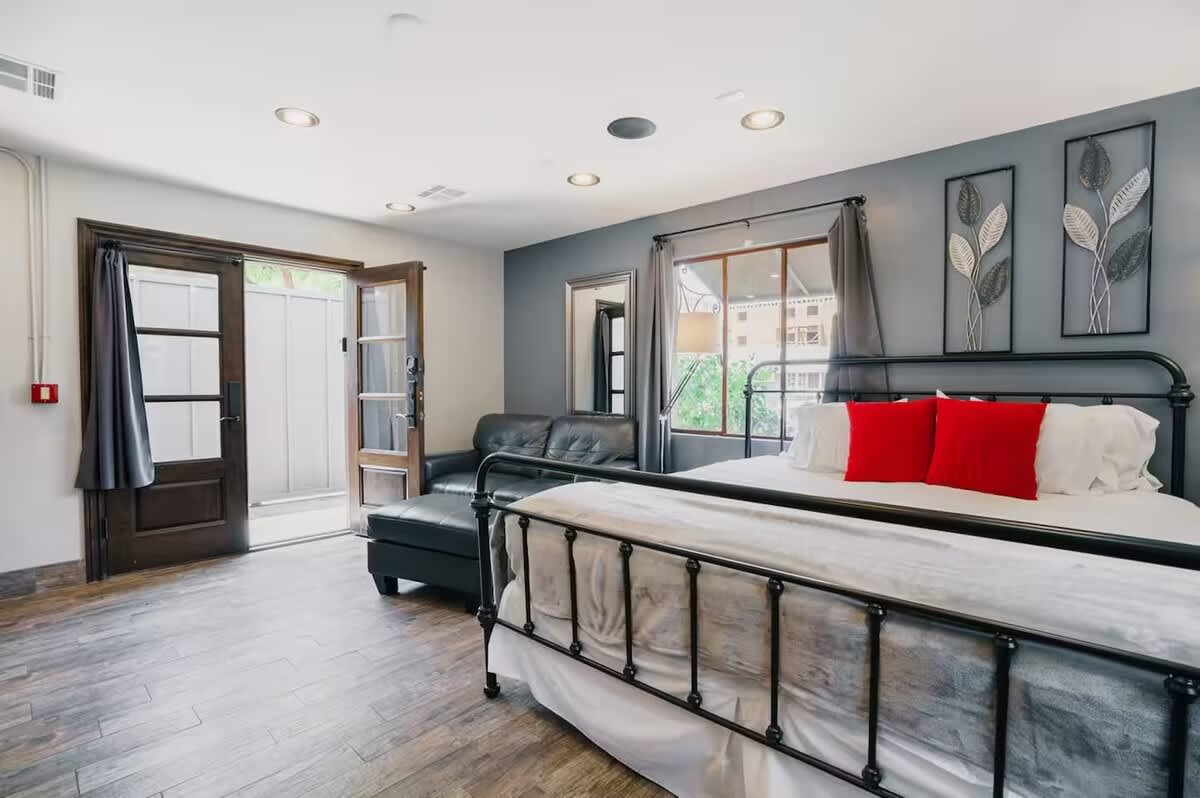 Bright and open bedroom featuring a King bed, smart TV, cozy furnishings, dining area, mini fridge, microwave, and an en-suite bathroom.