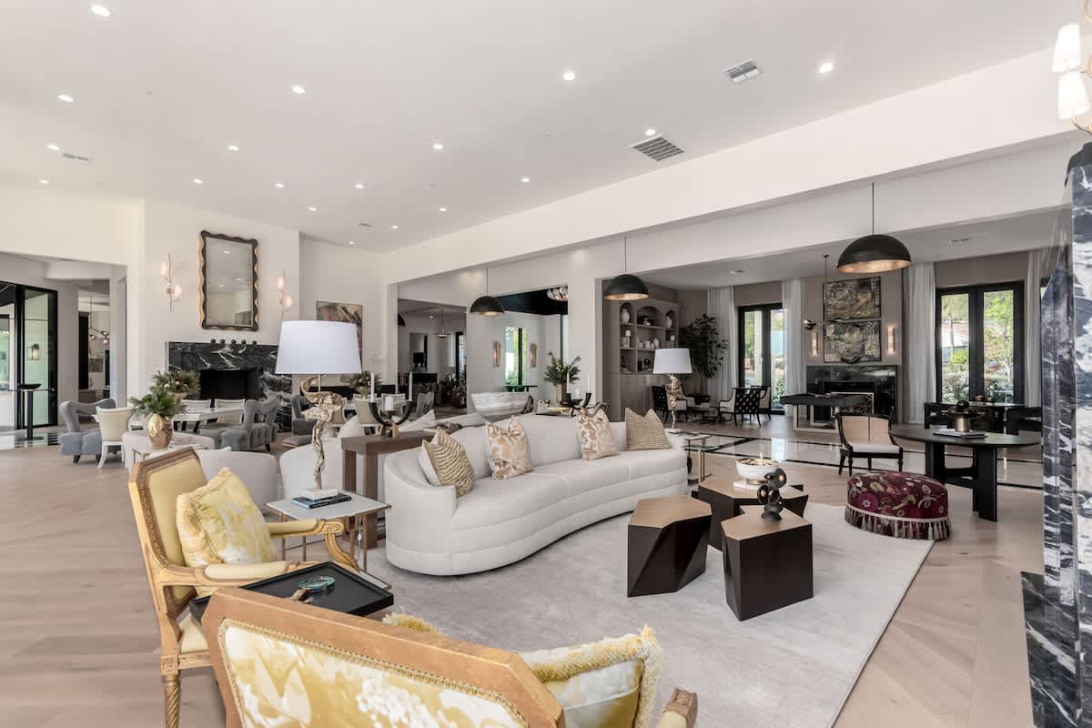 Massive open main living area featuring designer furnishings, 2 fireplaces, 2 dining areas, and access to the backyard.