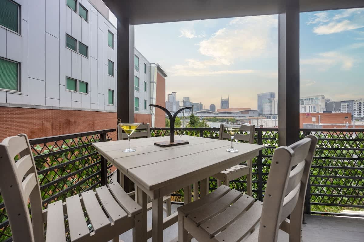 Oversized patio / balcony featuring outdoor dining and furnishings with cityscape views.