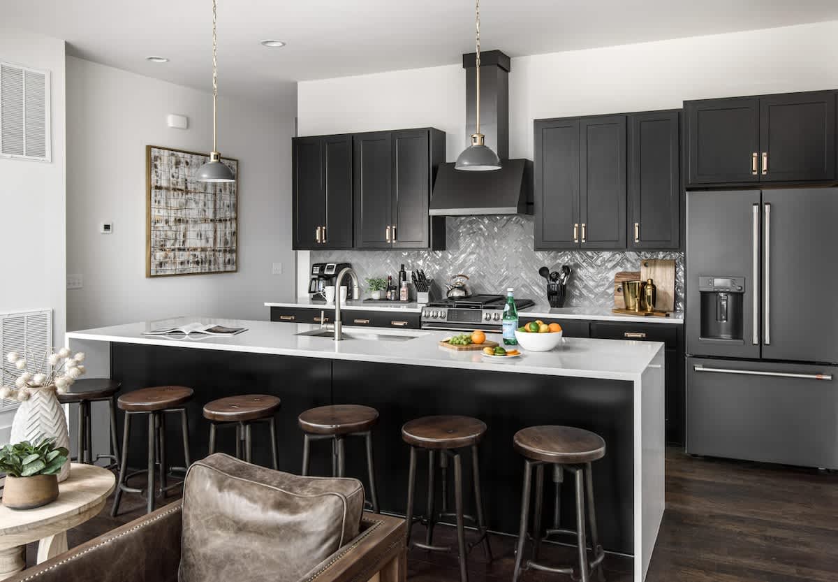 Fully equipped kitchen with stainless steel appliances, large island and bar seating.