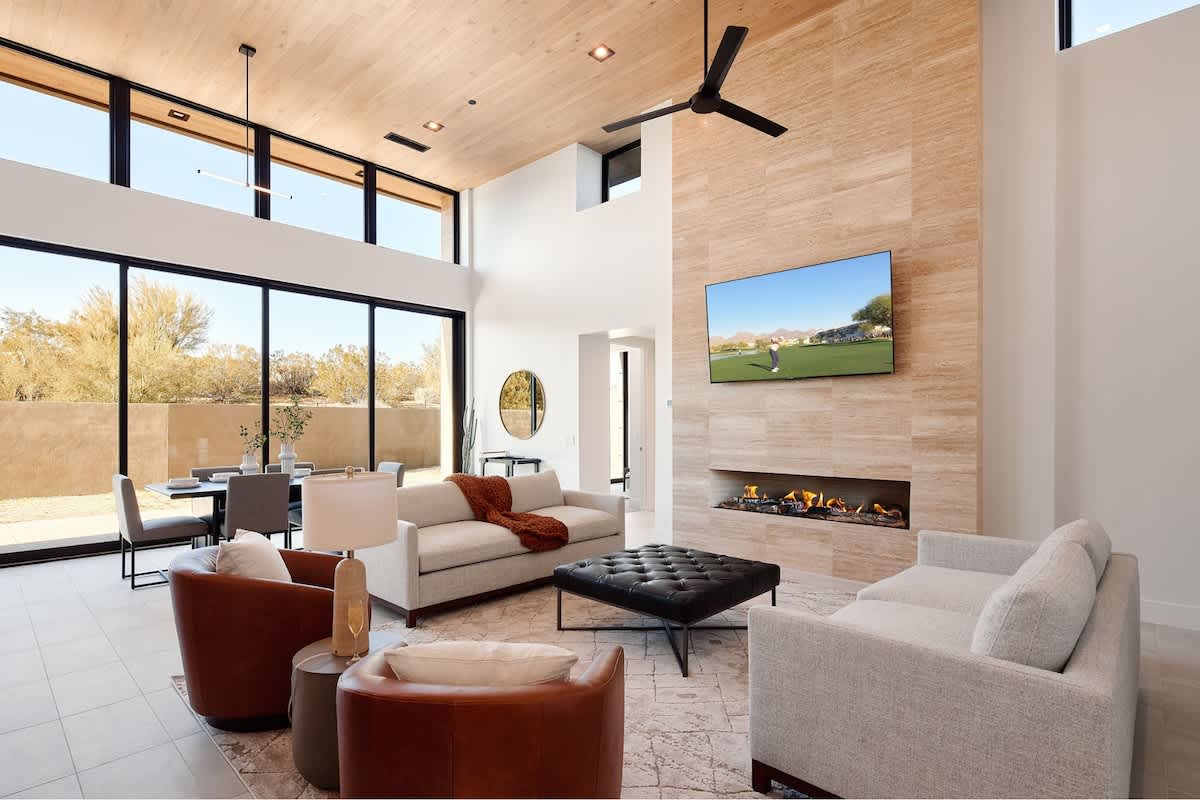 Bright and open living area featuring plush furnishings, a smart TV, and a fireplace.