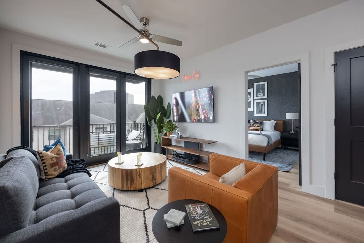 Bright living room with comfortable seating, smart TV, designer decor, and access to the private patio.