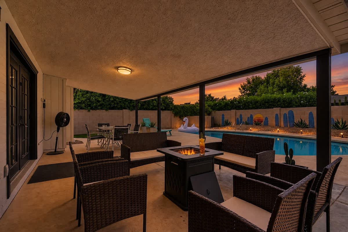 Private backyard with a sparkling pool, sun loungers, a covered patio with outdoor seating surrounding the fire pit and an outdoor dining area, plus a gazebo with a BBQ grill and a putting green.