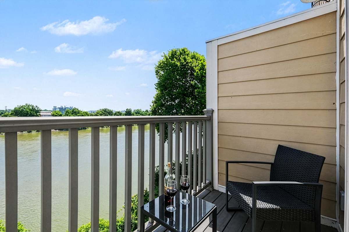 Private balcony with scenic views of the Cumberland River and comfortable seating, offering the perfect spot to enjoy your morning coffee or unwind with a drink while taking in the waterfront setting.
