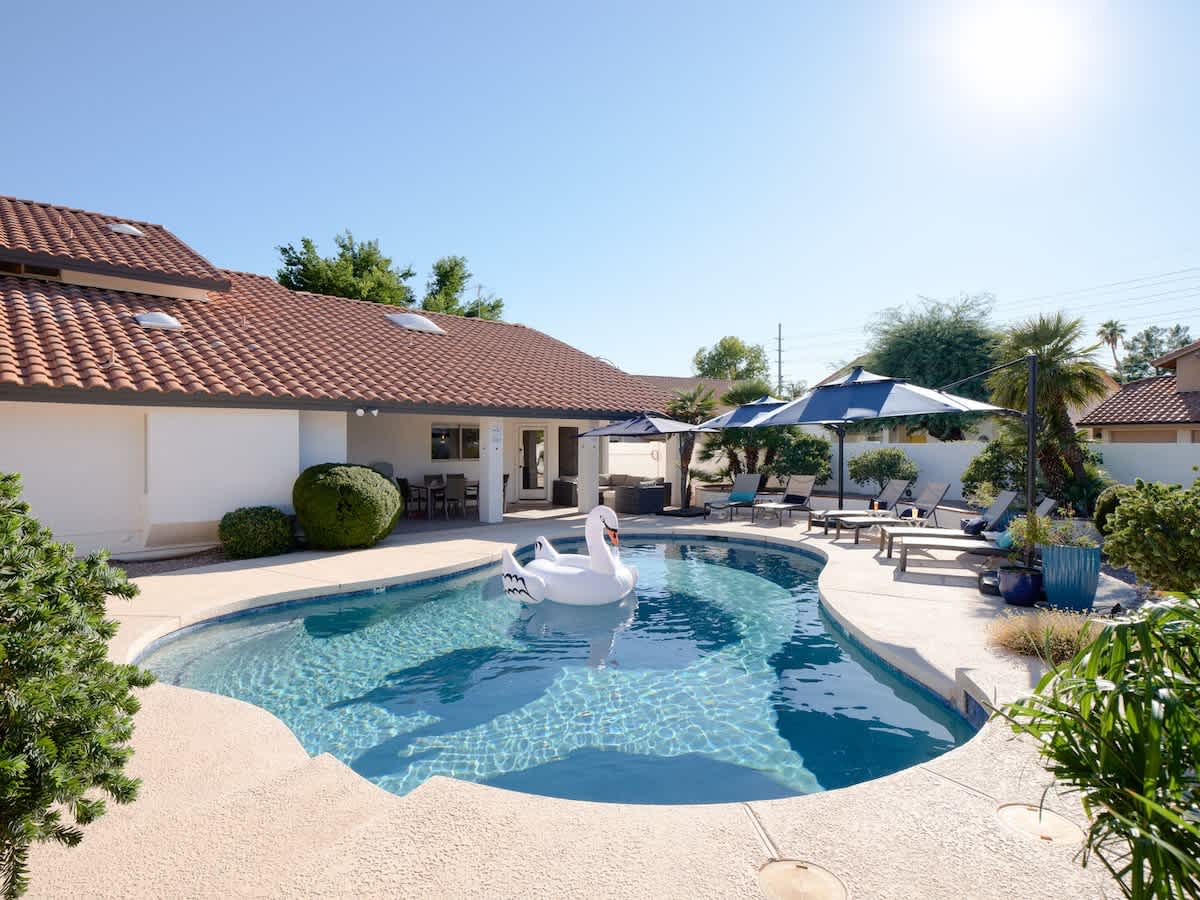 Outdoor oasis featuring a sparkling, heated optional pool, lounge chairs, outdoor dining table, BBQ grill, outdoor lounge areas, fire pit, putting green, bocce ball, & cornhole.