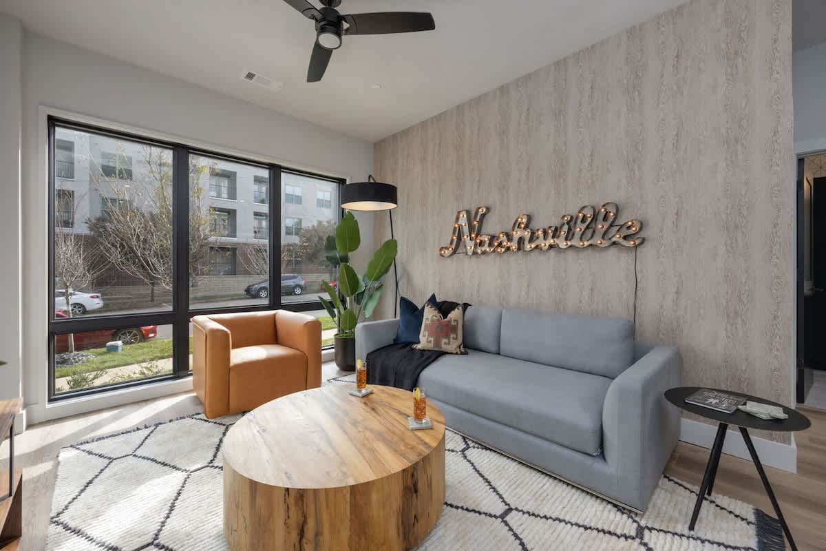 Bright living room with comfortable seating, pull out sofa, smart TV, complete with designer decor.