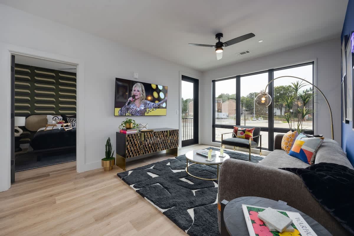 Open concept living area with floor to ceiling windows! Features designer furniture and smart TV!