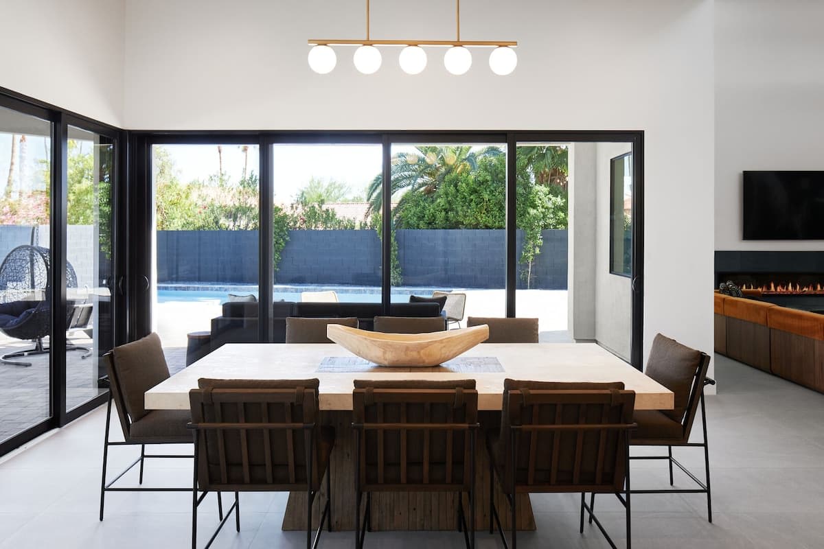 Formal dining area for 8 with custom light fixture, and large accordion style doors to the outdoor patio.