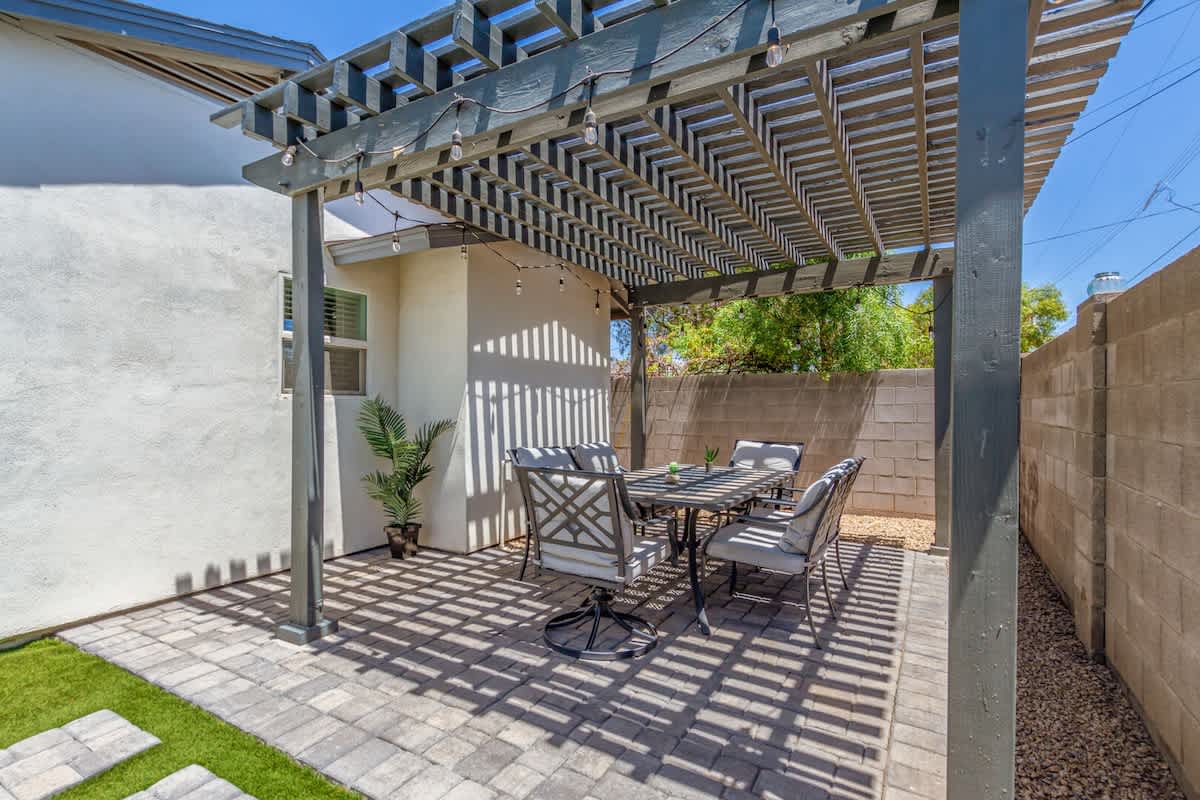 Stunning valley backyard featuring a sparkling blue heated pool with sun loungers, a BBQ grill, and outdoor dining while bistro lights set the mood.