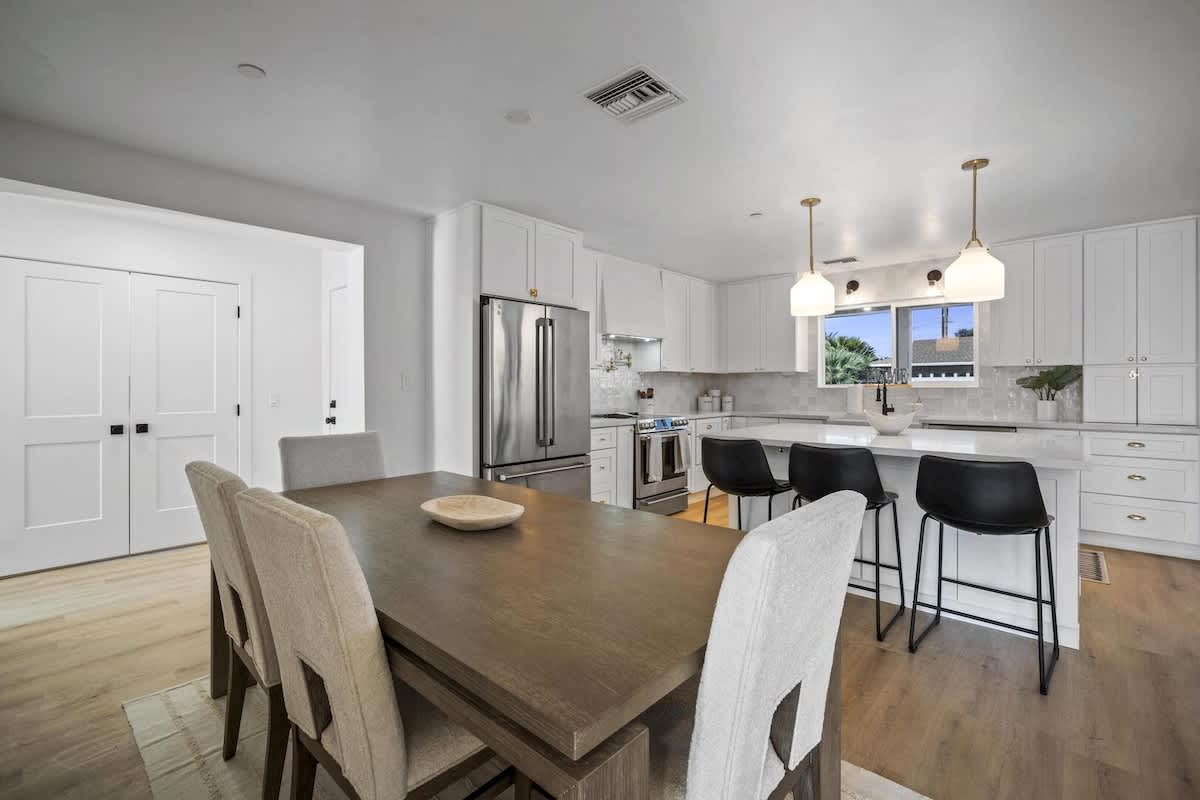 Inviting dining area featuring a spacious table that seats six, comfortable upholstered chairs, and a seamless flow into the modern kitchen.