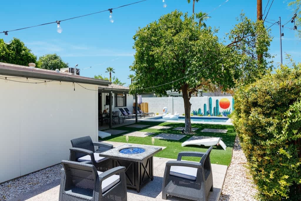 Backyard with pool, outside dining table, lounge chairs, BBQ grill, and bonfire pit.