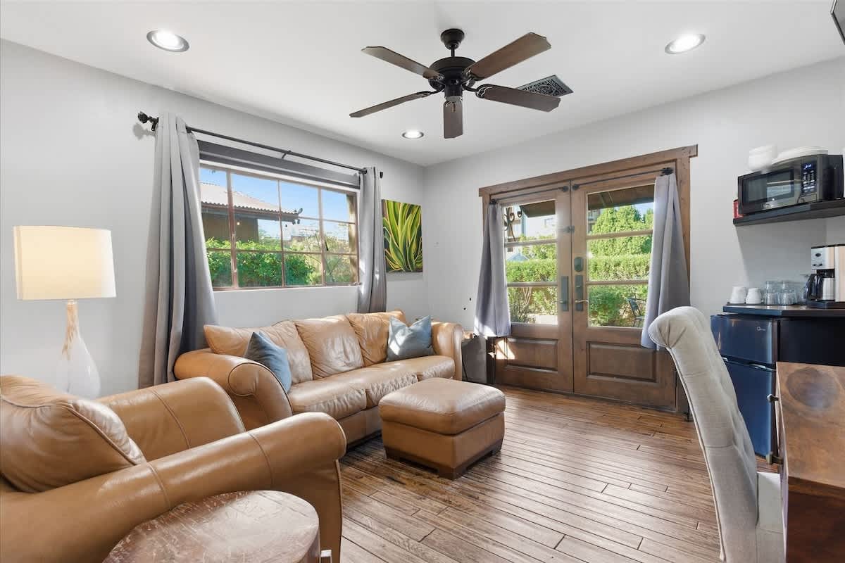 Unit 2: Bright and open living area featuring cozy furnishings, Smart TV, workstation with a desk and chair, mini fridge, microwave, and front yard access.