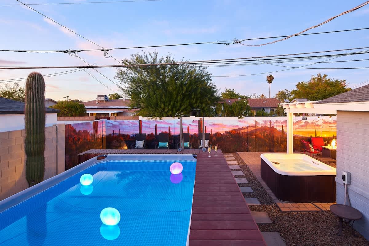 Private backyard patio with a new mural, outdoor dining area, ample seating, hot tub, above-ground pool, lounge chairs, fire pit, BBQ grill, ping pong table, and horseshoe.