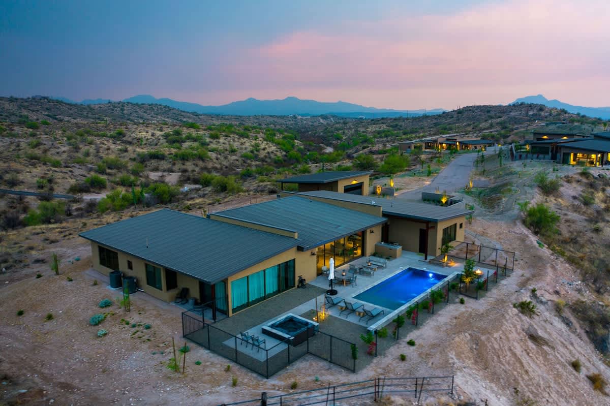 Estate 2: Stunning private oasis featuring a sparkling blue pool and spa with sun loungers, a patio with a BBQ grill, outdoor furnishings for lounging and dining, and a fire pit surrounded by unparall