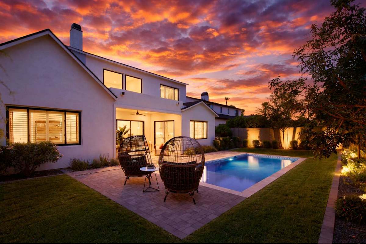 Private backyard with a sparkling pool and a covered patio with outdoor seating.