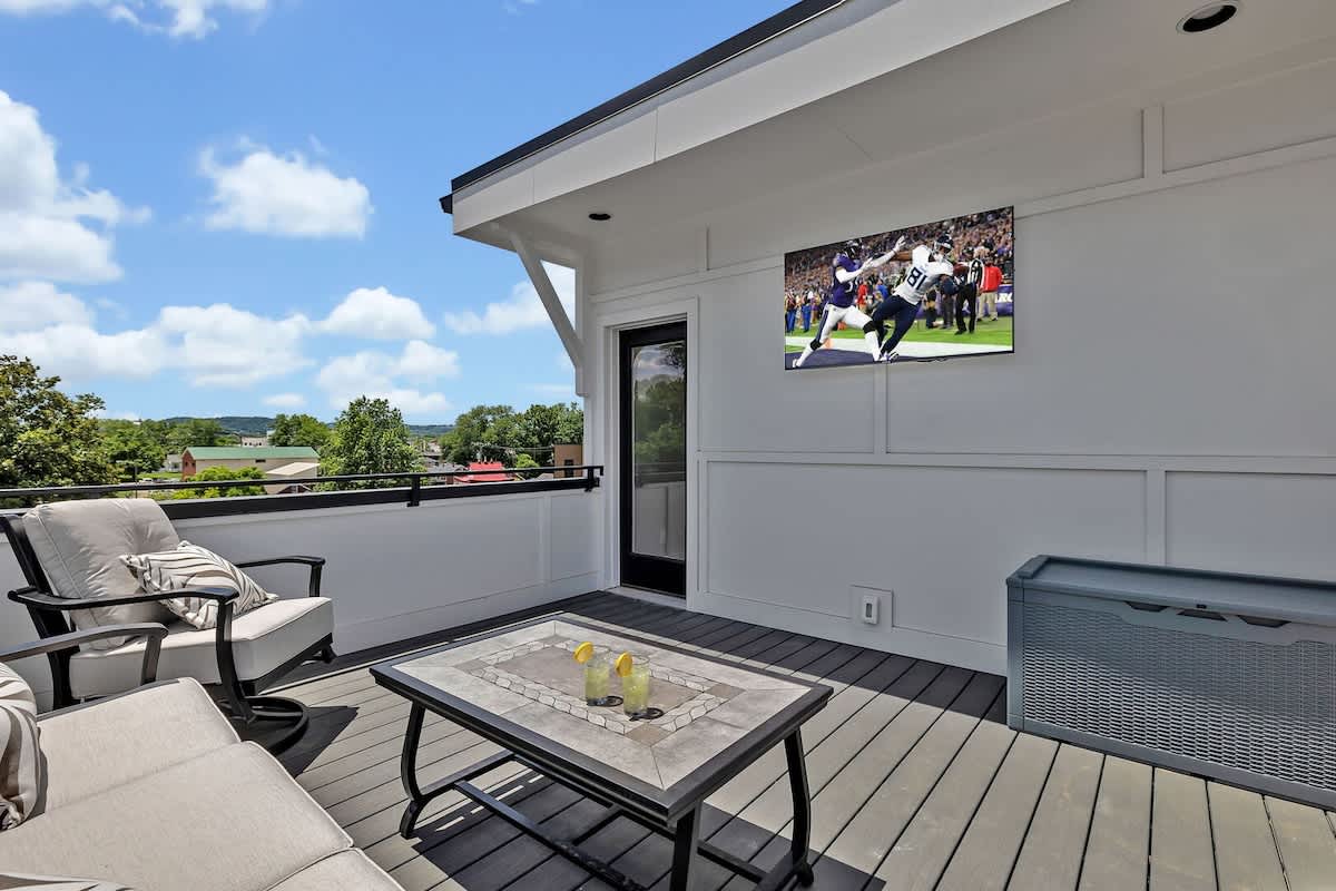 4th Floor: Private rooftop patio featuring outdoor furnishings for lounging and a Smart TV for entertainment surrounded by beautiful neighborhood views.