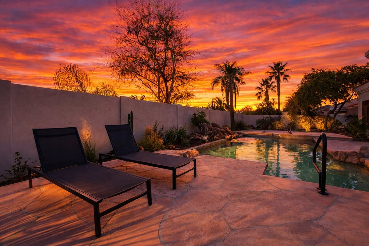Outdoor sparkling, heated optional pool and hot tub, lounge chairs, outdoor dining table, built-in BBQ grill, and outdoor seating.