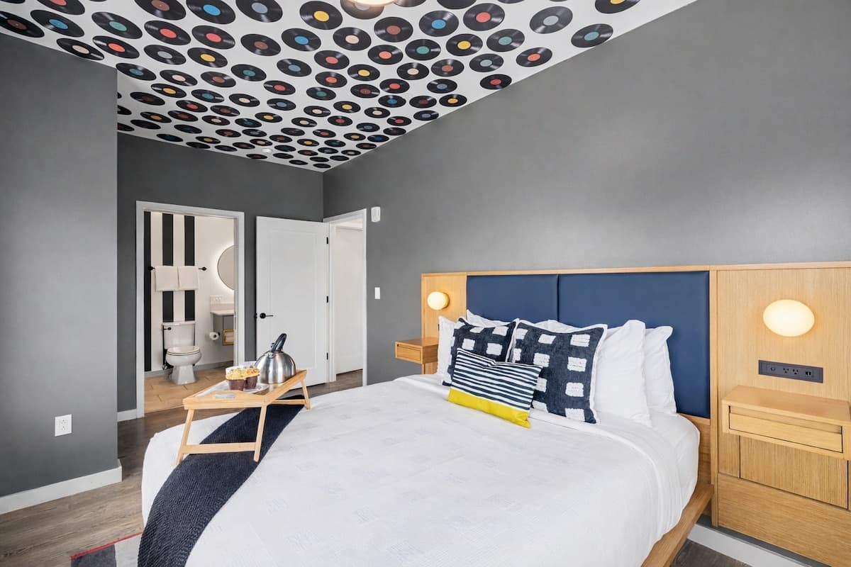The primary bedroom has a Queen bed, a smart TV, a built-in wardrobe, and an en-suite bathroom.