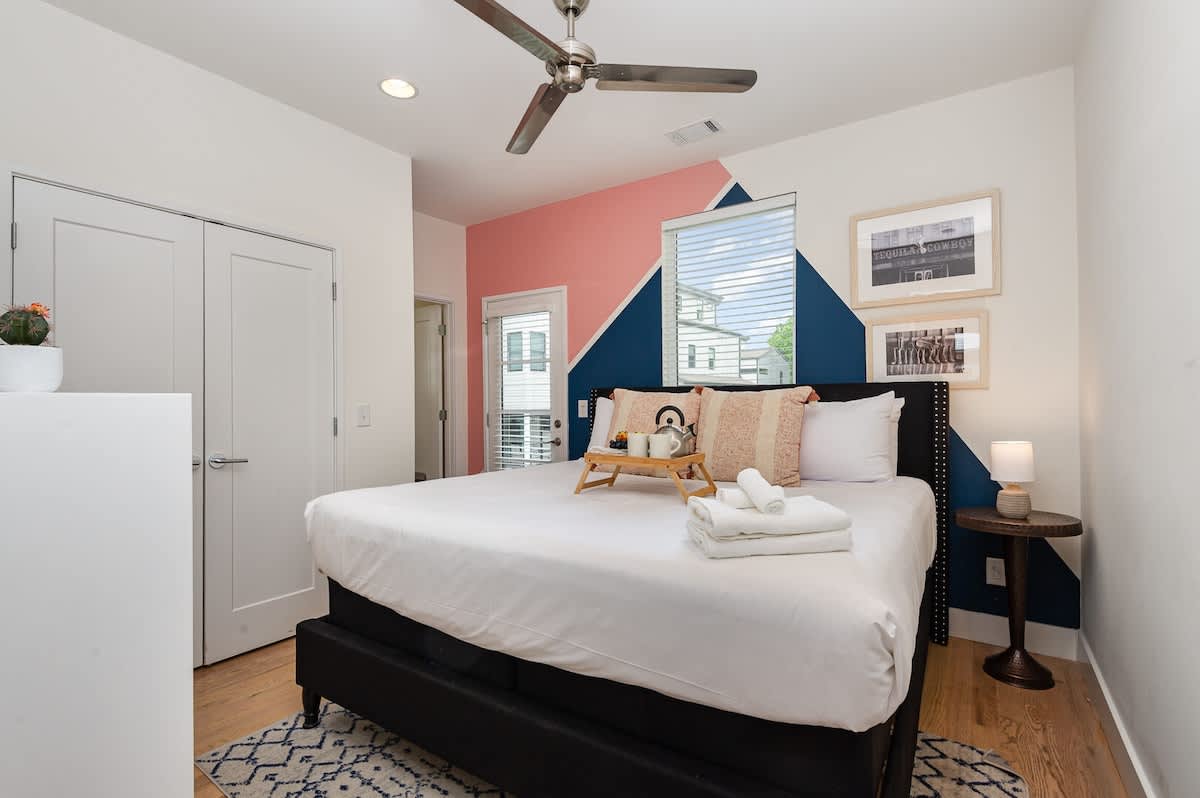 Primary Bedroom featuring a King Bed, dresser, en-suite bathroom, and private balcony.