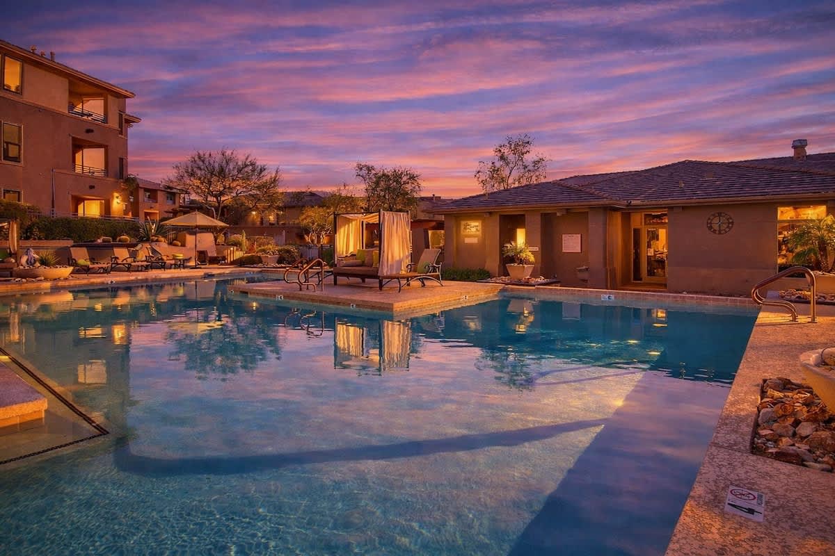 Communal Area: Sparkling blue pool and hot tub with covered cabanas, and sun loungers.