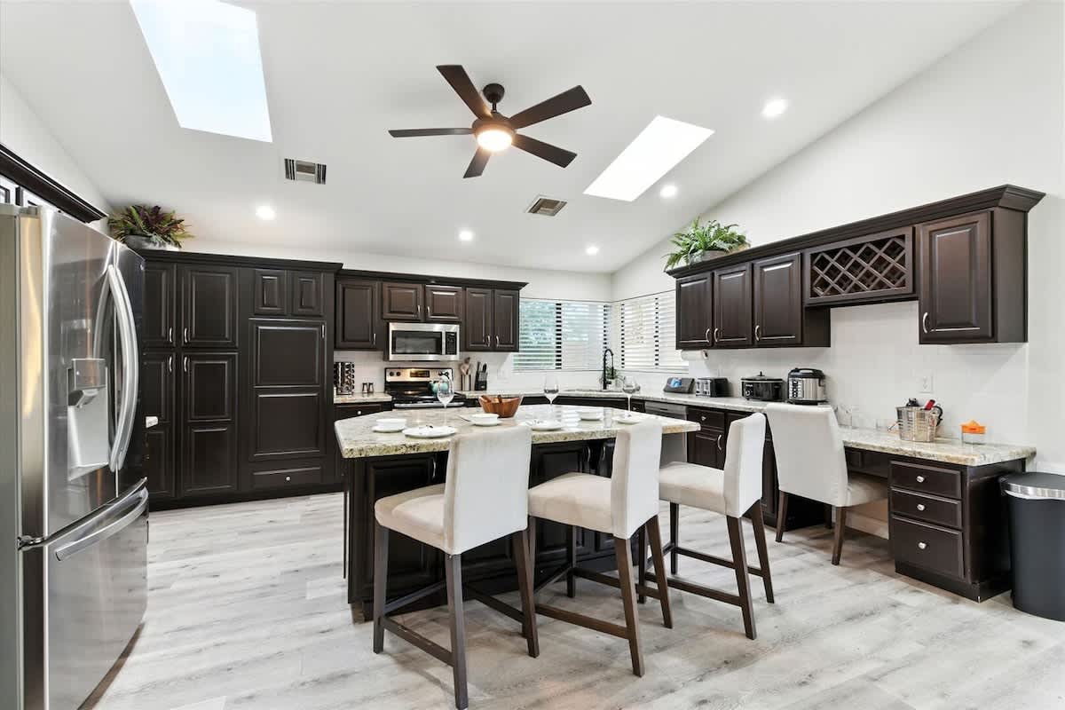 The kitchen features granite countertops, stainless steel appliances, and a spacious island with seating for family and friends.