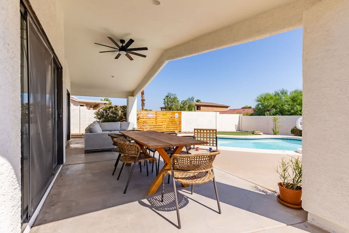 Sparkling heated pool, putting green, fire pit, sun loungers, BBQ, cornhole, and outdoor patio furniture, plus dining area.