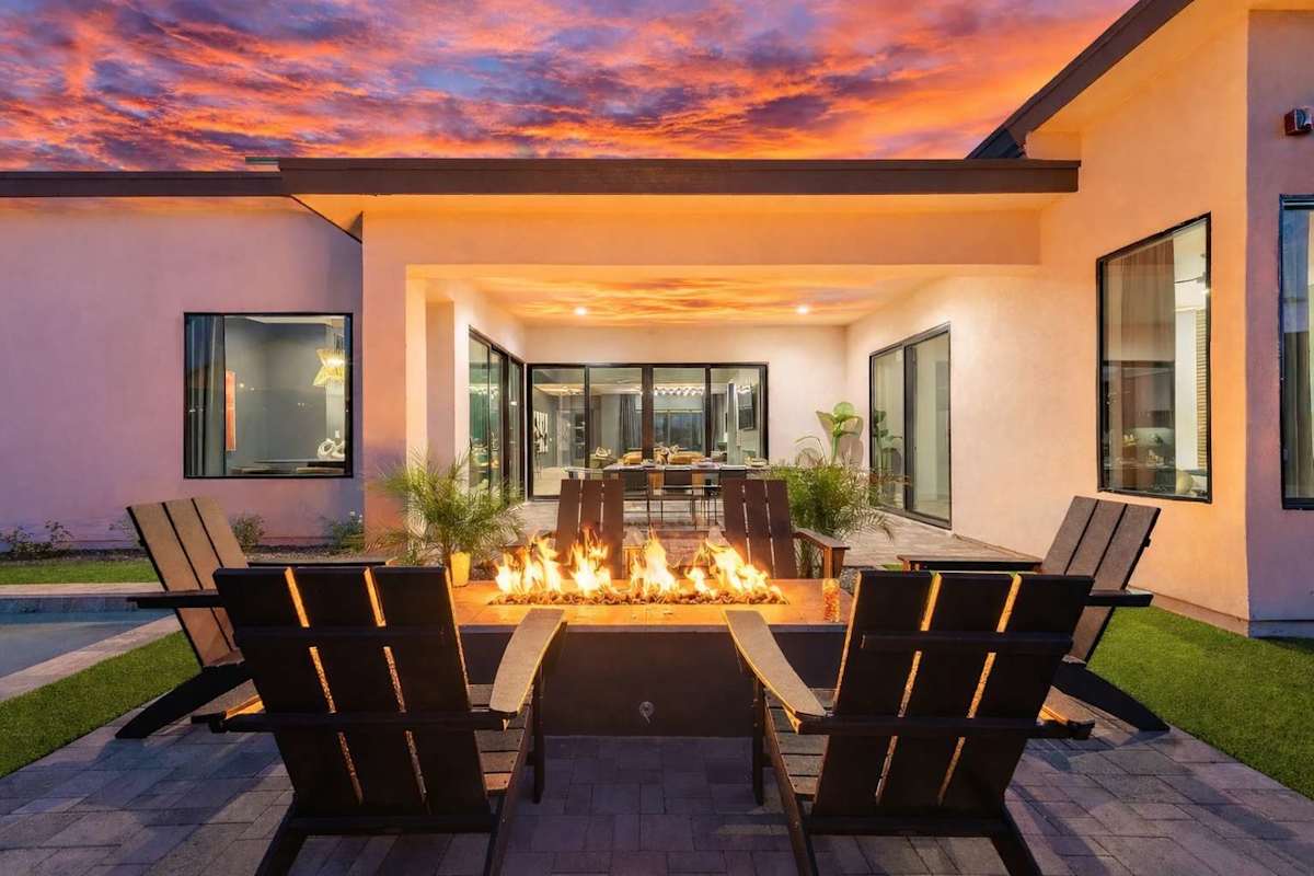This stunning private yard features a sparkling pool, covered outdoor dining area, sun loungers, lawn space, built-in fire pit & BBQ Grill!