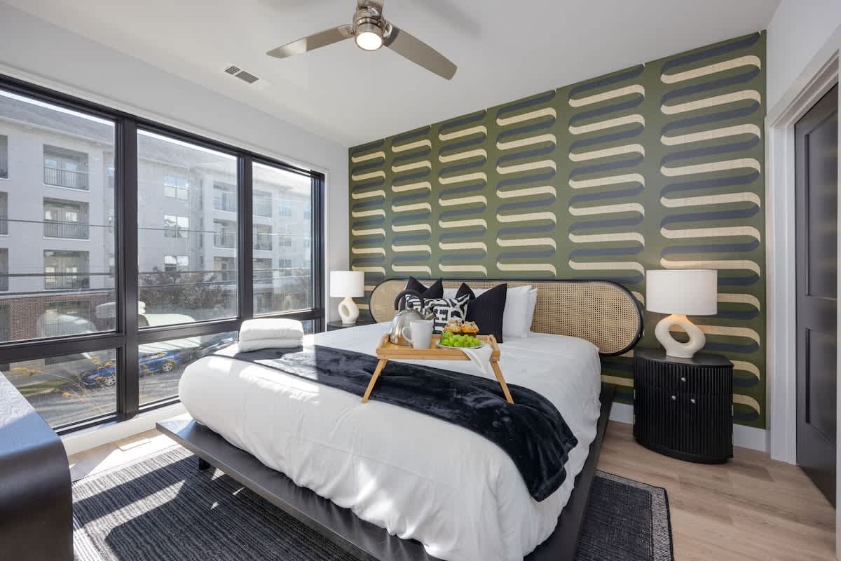 Unit 1: Primary bedroom with King bed, smart TV, large walk-in closet, and ensuite bathroom with walk-in shower.