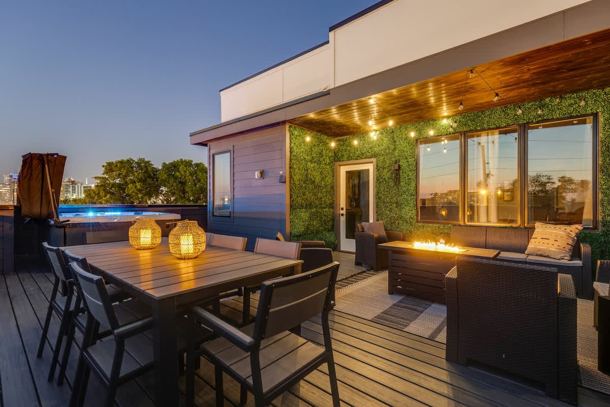 Private rooftop deck with outdoor fire pit, lounge area, dining area, BBQ grill, twinkling bistro lights, and HOT TUB.