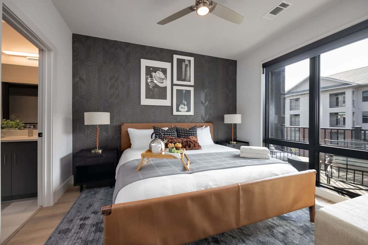 Primary Bedroom with King bed, smart TV, floor to ceiling windows, and en-suite bathroom.