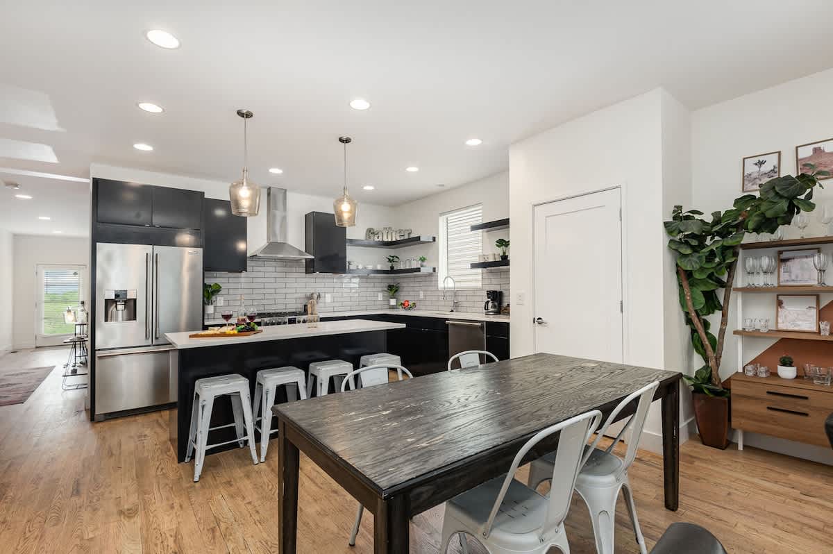 Fully Equipped Kitchen with stainless steal appliances, bar seating, and a dining area.