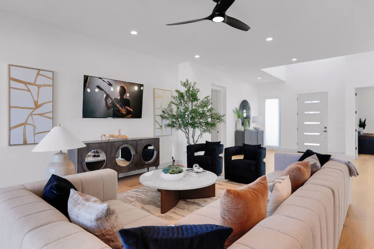 Bright open floor living space, designer furnishings, smart TV, and large sliding doors leading to the private outdoor oasis. (1st Floor)