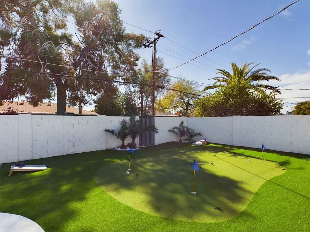 Spacious Entertainers Backyard featuring a Sparkling Blue Pool, Putting Gree, BBQ Grill, Outdoor Furnishings, Fire Pit, and Yard Games