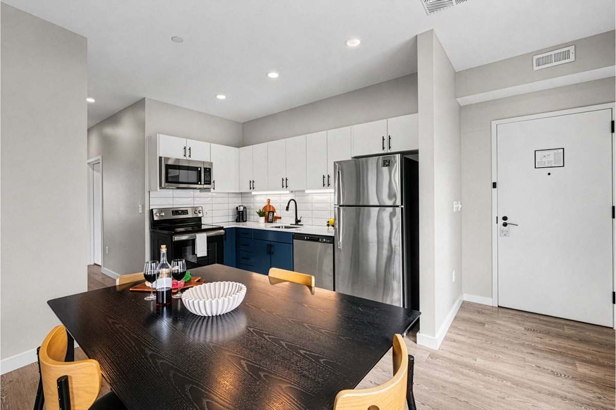 Modern dining area with comfortable seating for four, conveniently located next to the kitchen for easy serving and relaxed meals together.
