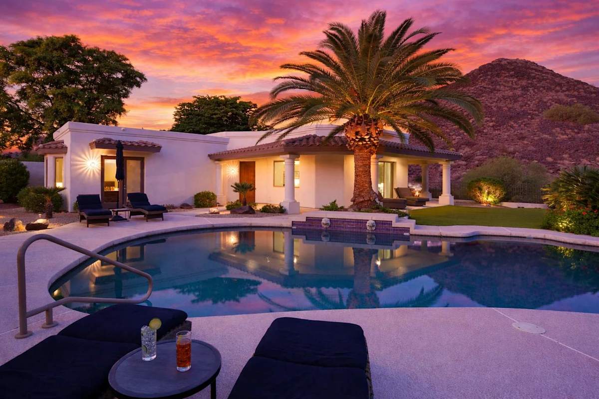Resort style backyard with private pool, hot tub, lounge chairs, outdoor dining, corn hole, built in grill and fire pit!