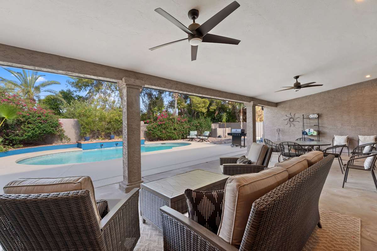 Private backyard oasis featuring a sparkling pool, covered patio lounge, outdoor dining area, BBQ grill, and plenty of space to soak up the Arizona sunshine.