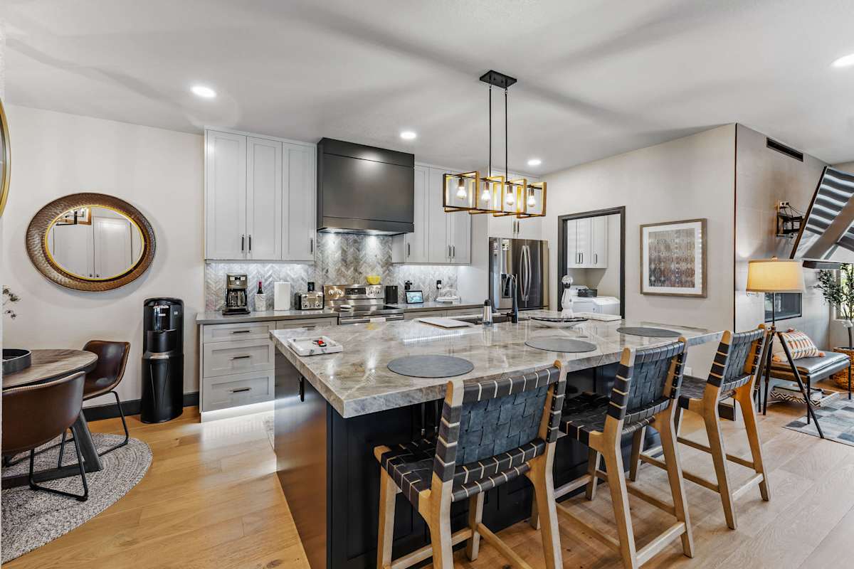 Gather in this beautifully updated chef-inspired kitchen, featuring a stunning oversized island, sleek stainless appliances, and stylish bar seating.