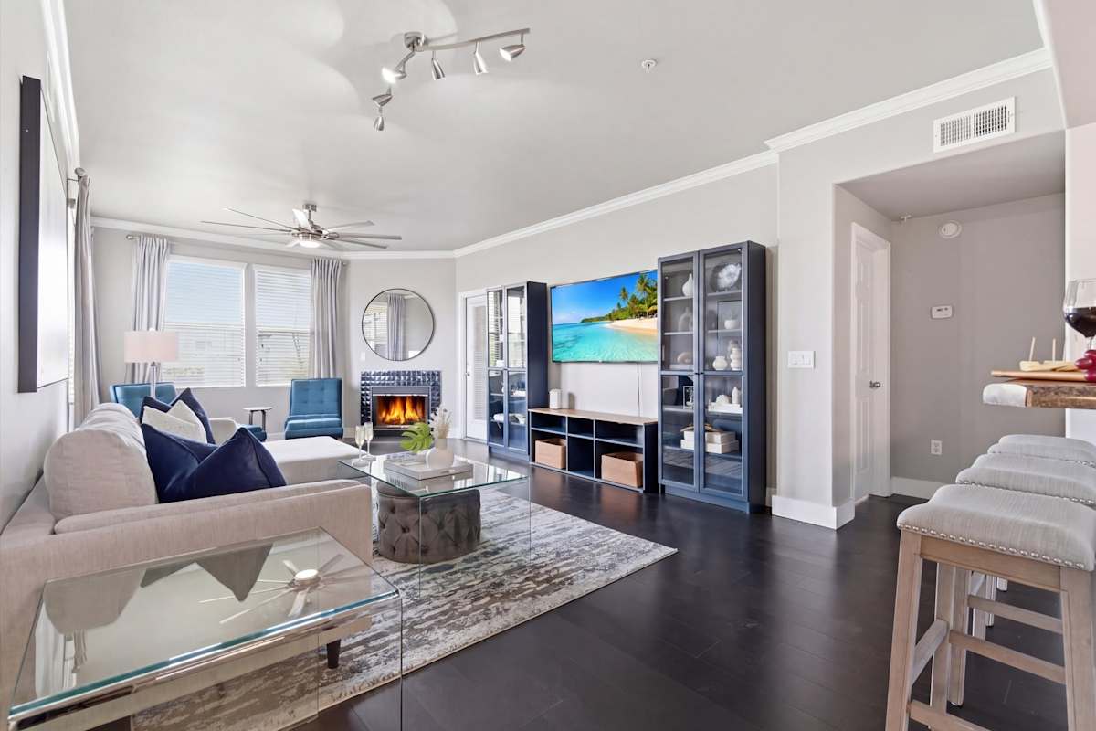 Bright and open living area featuring cozy furnishings, a Smart TV, fireplace, and access to the private balcony.