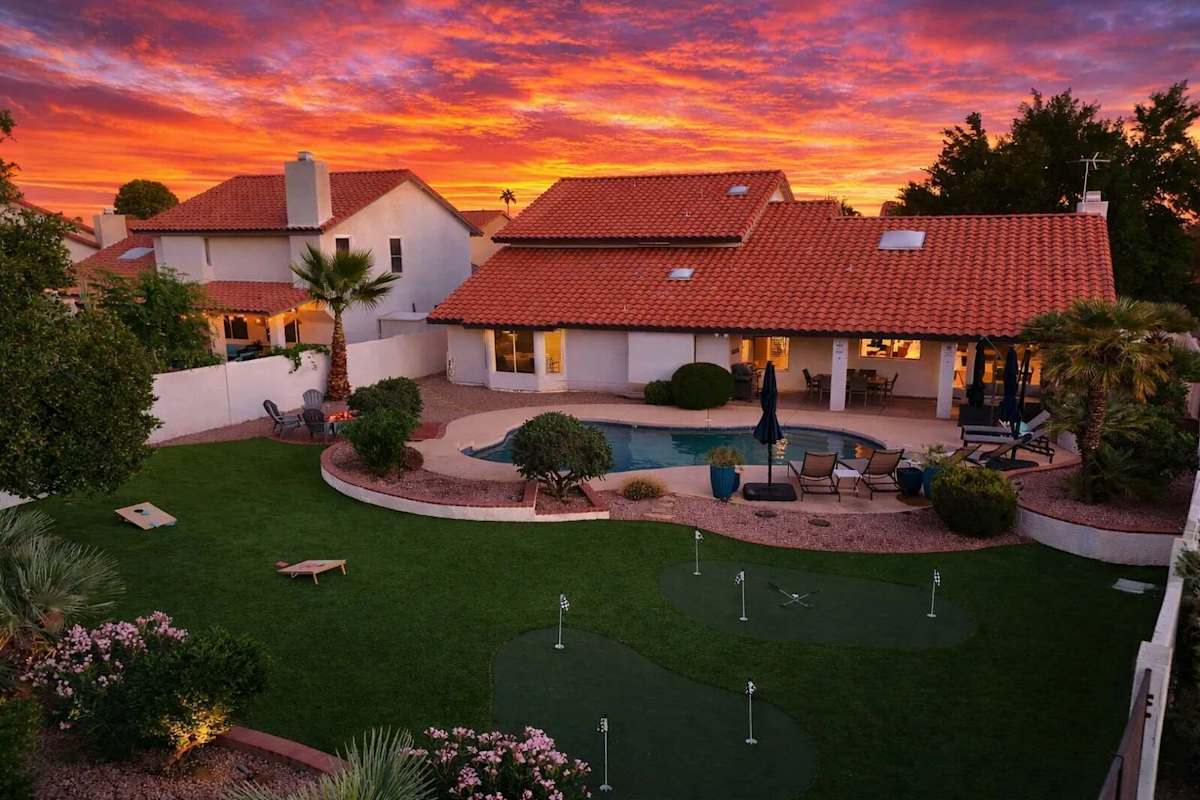 Outdoor oasis featuring a sparkling, heated optional pool, lounge chairs, outdoor dining table, BBQ grill, outdoor lounge areas, fire pit, putting green, bocce ball, & cornhole.