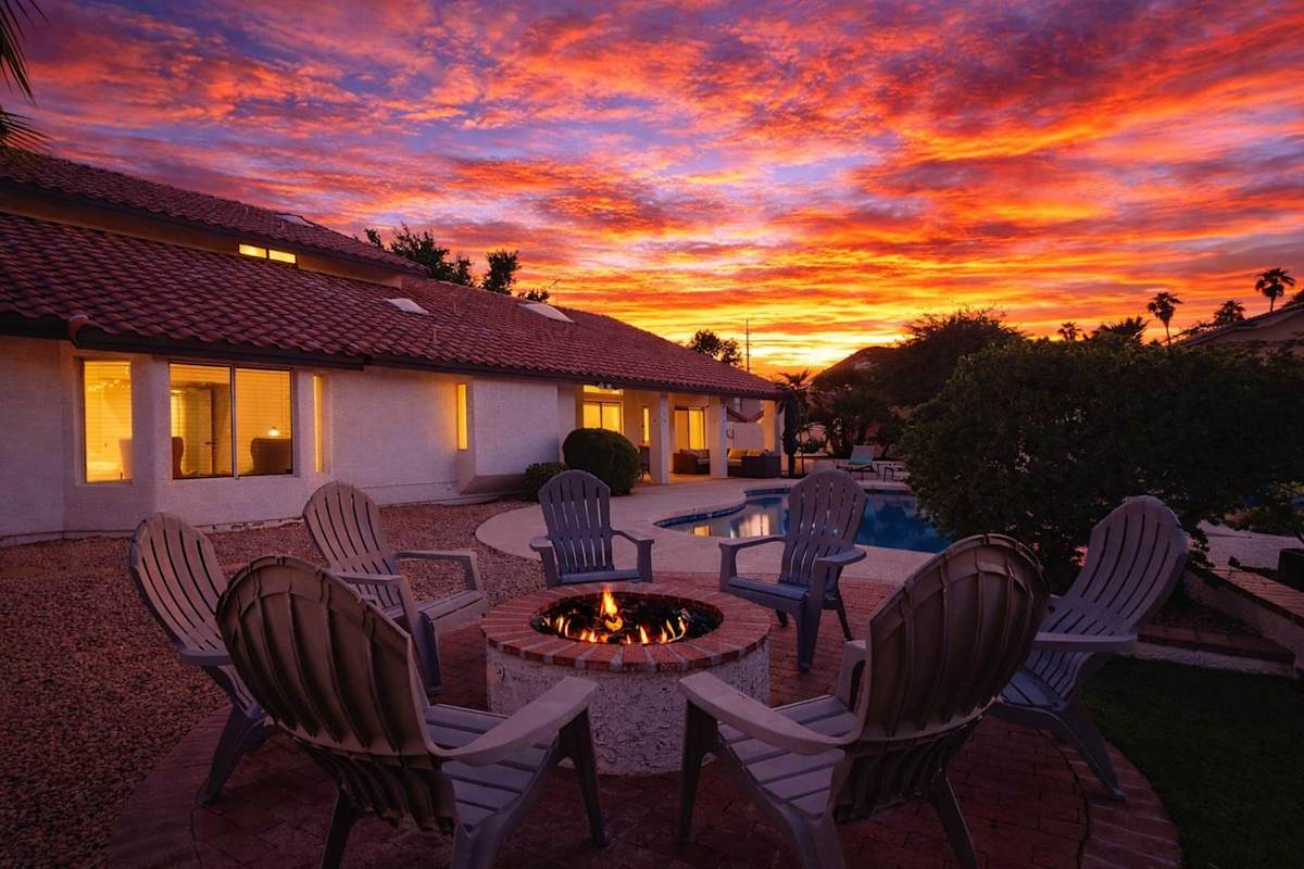Outdoor oasis featuring a sparkling, heated optional pool, lounge chairs, outdoor dining table, BBQ grill, outdoor lounge areas, fire pit, putting green, bocce ball, & cornhole.