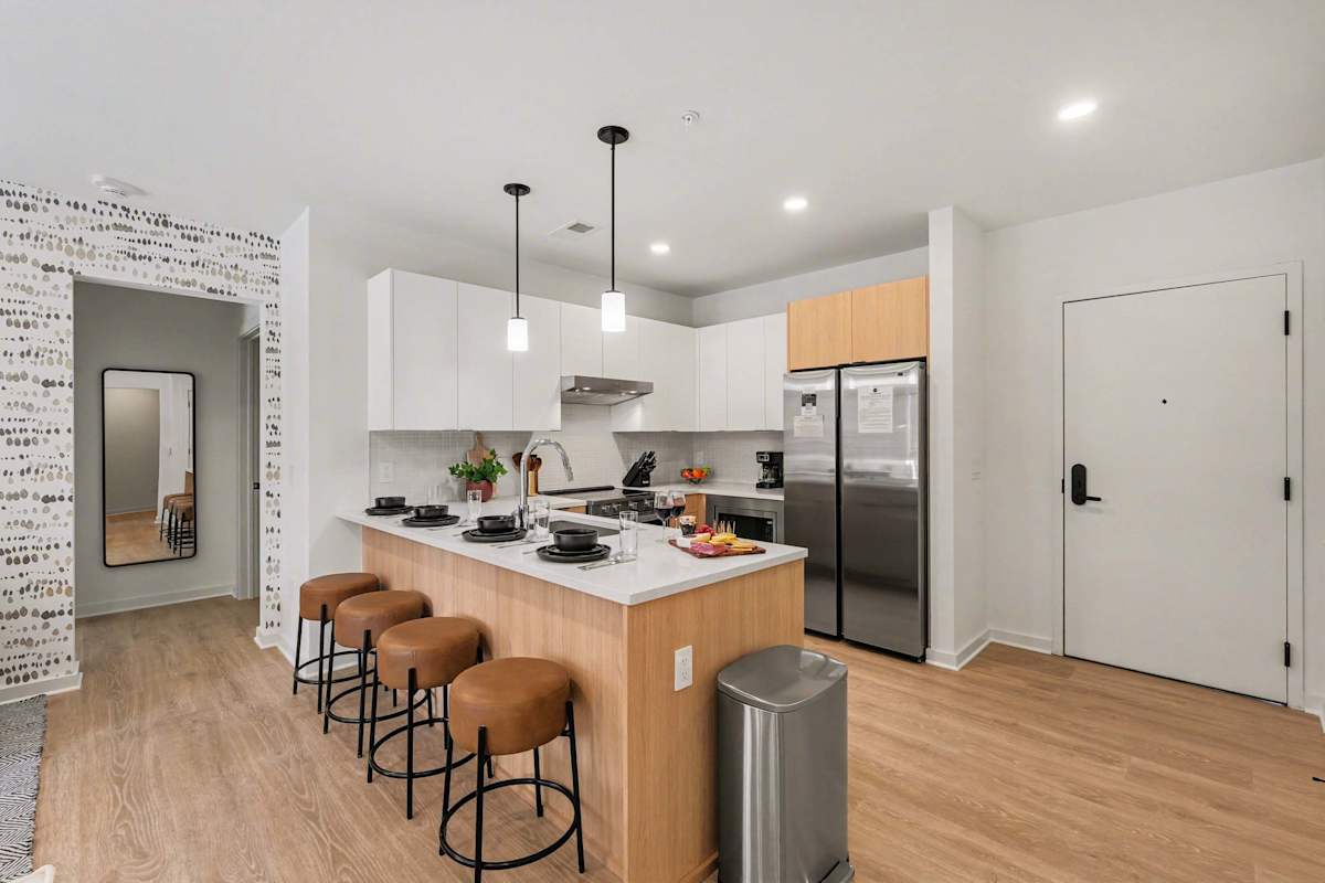 Fully equipped modern kitchen stocked with all culinary essentials and featuring stainless steel appliances with island bar seating.