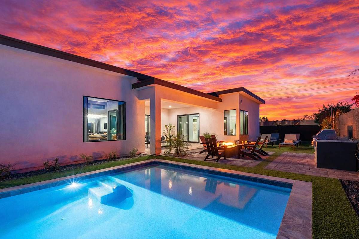 This stunning private yard features a sparkling pool, covered outdoor dining area, sun loungers, lawn space, built-in fire pit & BBQ Grill!