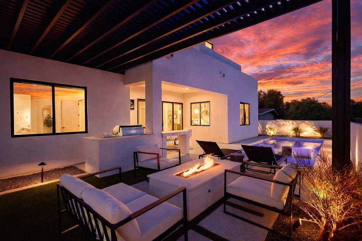 Outdoor oasis featuring a sparkling, heated optional pool & hot tub, multiple seating areas, lounge chairs, BBQ grill, firepit, and outdoor smart TV.