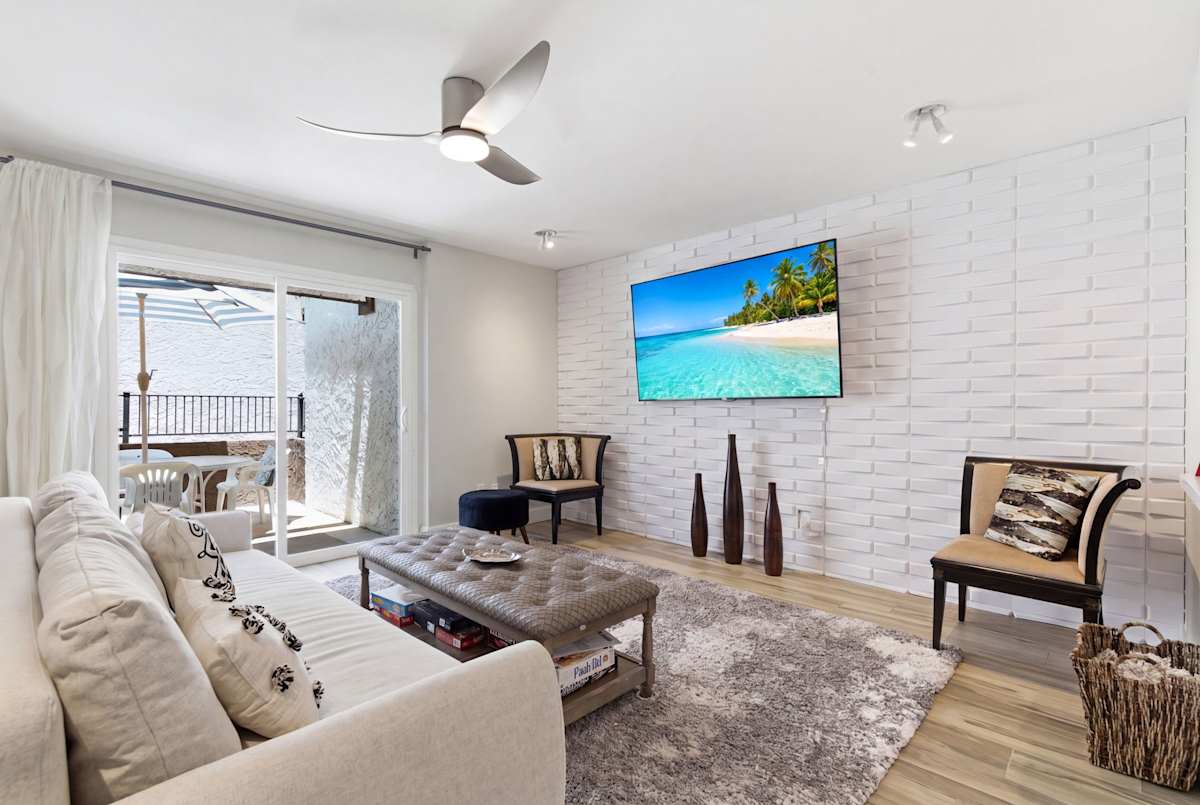 Chic living room with a comfy sofa that doubles as a sleeper, Smart TV, board games, and private patio access for easy indoor-outdoor relaxation.